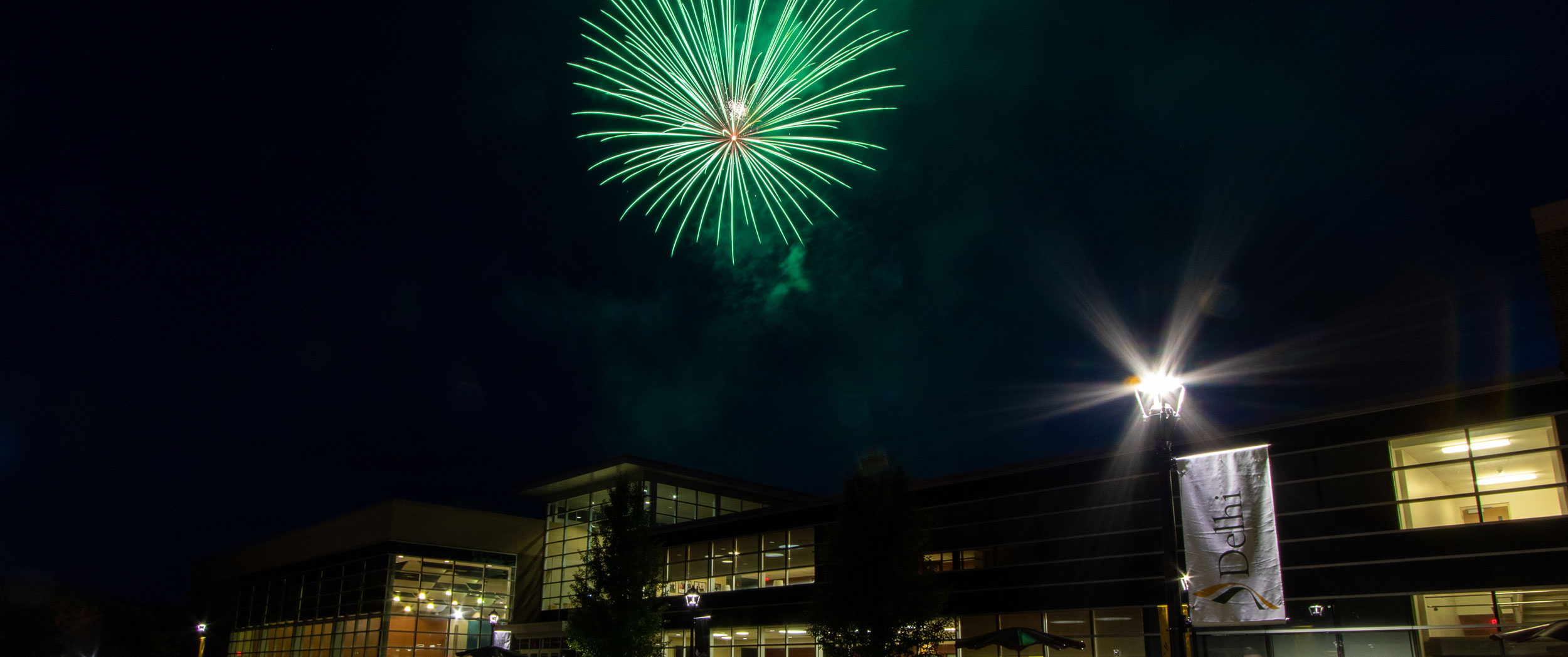 SUNY Delhi at night with fireworks in the sky